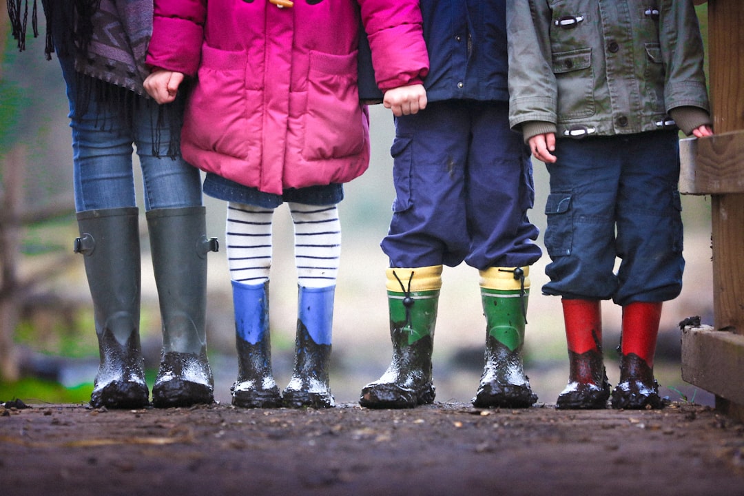 Playing in mud and streams is the best thing. This is three of my nephews / nieces and one of my kids after some muddy fun at Mottisfont house in Hampshire. Mottisfont is well worth a visit, a fantastic old house set in beautiful gardens along the river Test. by Learning Game four children standing on dirt during daytime